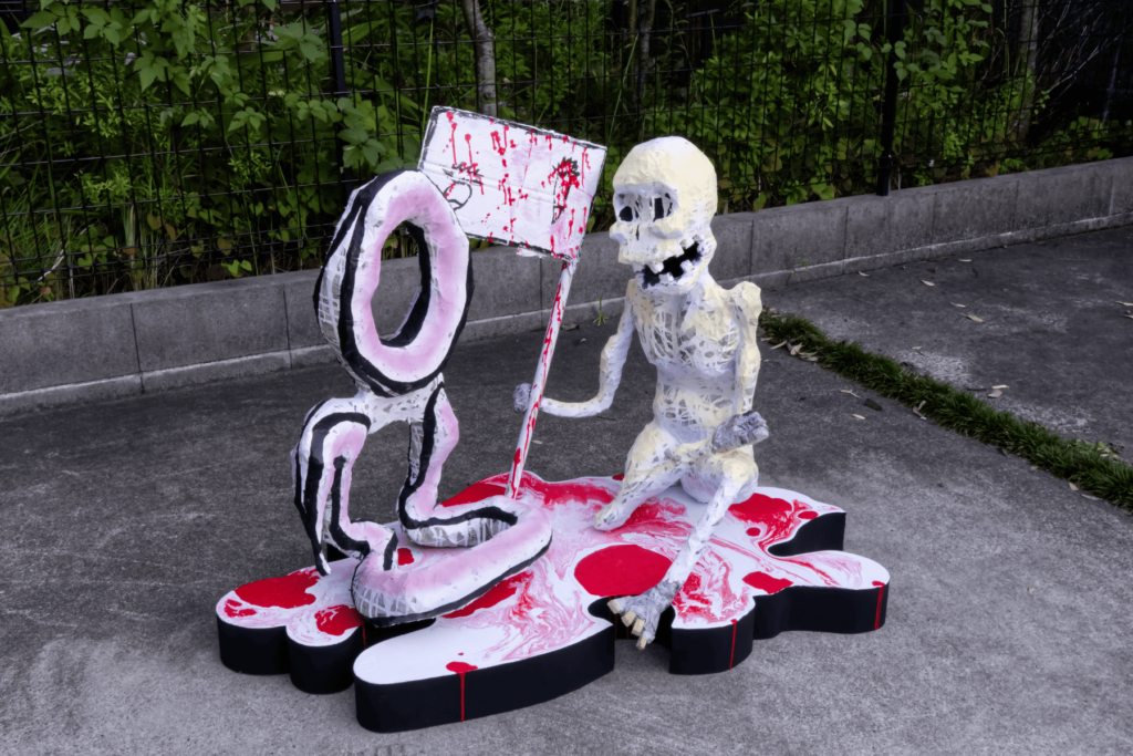 Tweedle Death and Tweedle Done, a paper mache painted sculpture with wood base